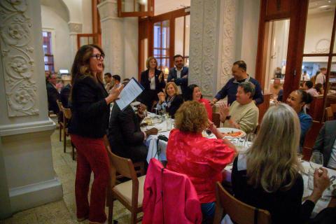 Guests seated at a lively dinner event in an elegant room.